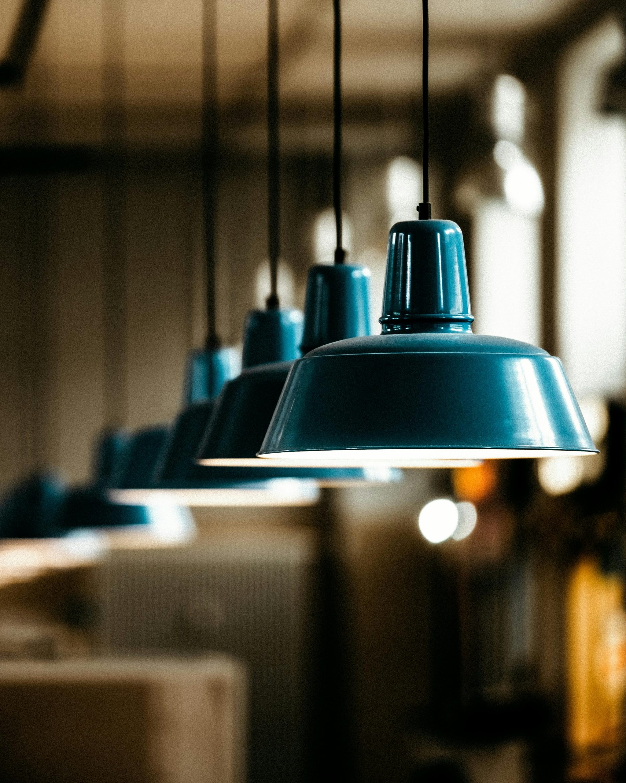 A row of stylish pendant lamps in an industrial setting, providing ambient lighting